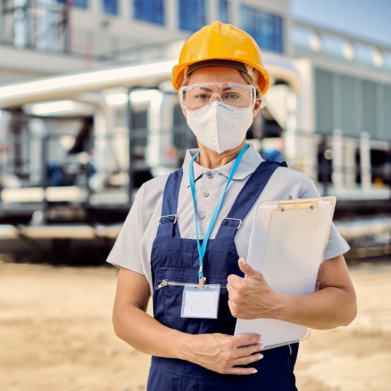 Portrait of female civil engineer with protective face at constr