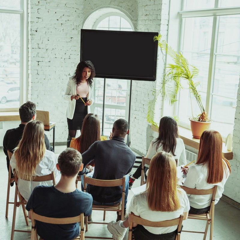 Female african-american speaker giving presentation in hall at university workshop